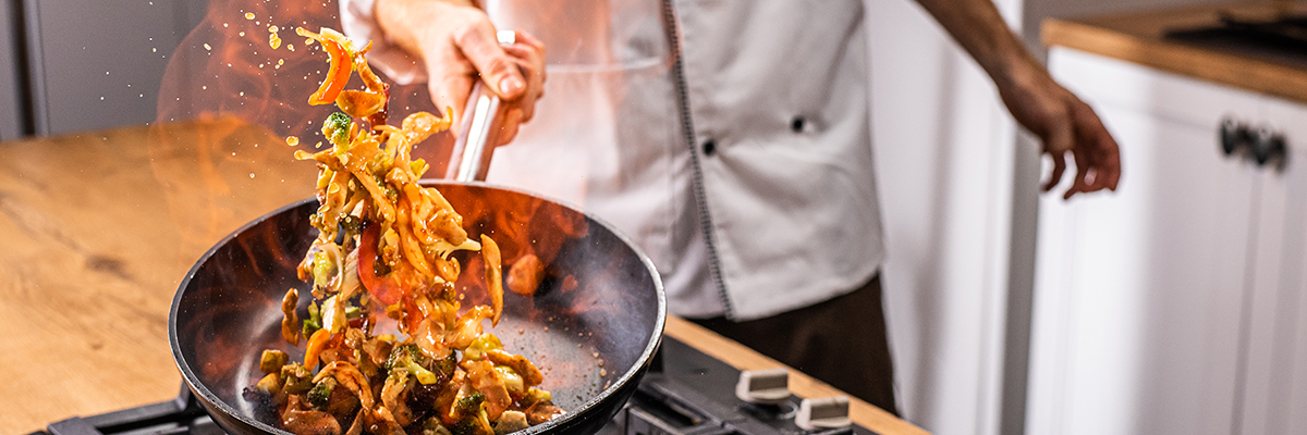 Personal chef flambéing a dish