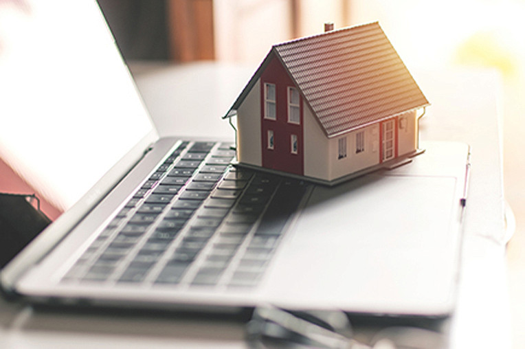 Model house on laptop keyboard