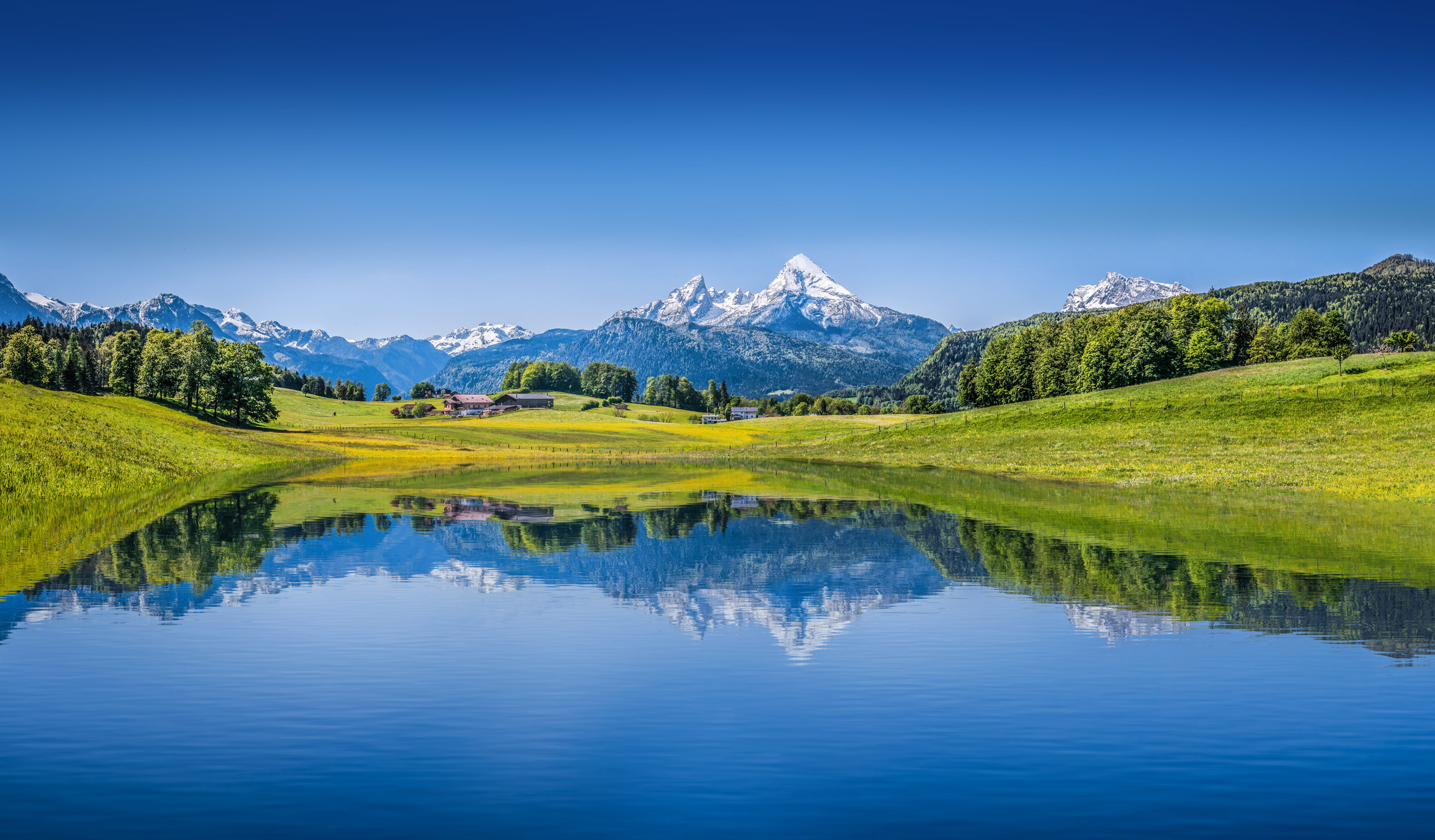 Alpine lake in the bottom of a valley with mountians in the distance